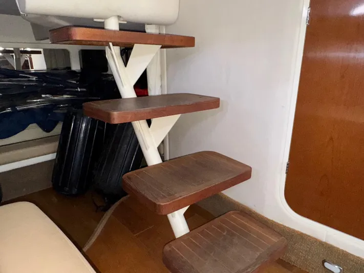Max Dream Yacht Photos Pics Interior stairs of a 2014 Sea Ray 330 Sundancer yacht, featuring wooden steps.
