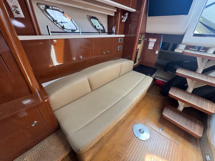 Max Dream Yacht Photos Pics Interior of 2014 Sea Ray 330 Sundancer with beige sofa and wooden cabinetry.