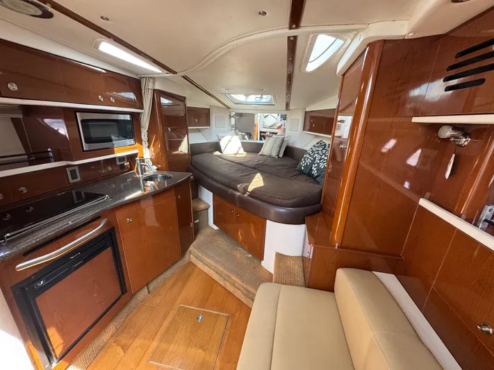 Max Dream Yacht Photos Pics 2014 Sea Ray 330 Sundancer interior with kitchen, bed, and seating area.