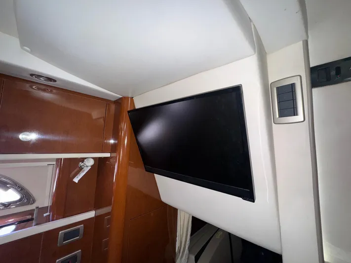 Max Dream Yacht Photos Pics Interior of 2014 Sea Ray 330 Sundancer with mounted flat-screen TV and wooden cabinetry.