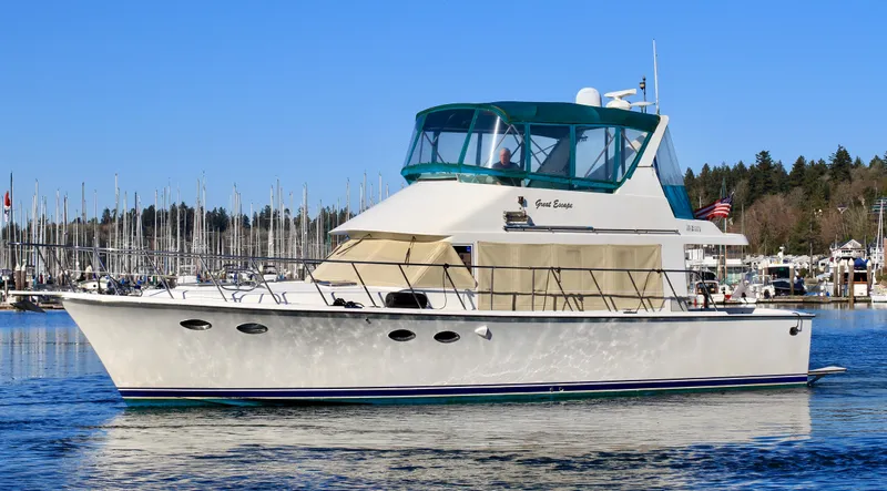  Yacht Photos Pics 1999 McKinna 47 Sedan yacht on calm water with marina background.