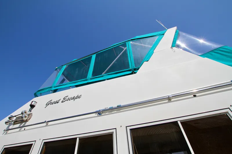 Yacht Photos Pics 1999 McKinna 47 Sedan yacht with teal accents under clear blue sky.