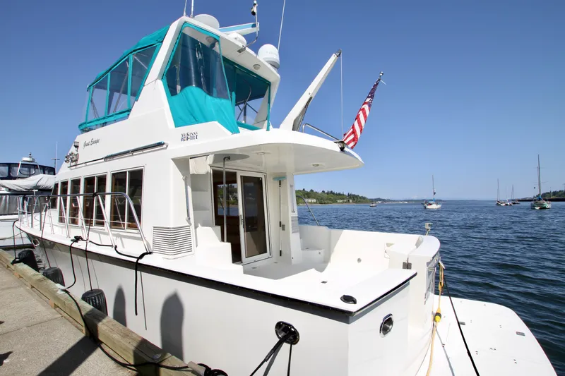  Yacht Photos Pics 1999 McKinna 47 Sedan yacht docked by the water, featuring a sleek design and American flag.