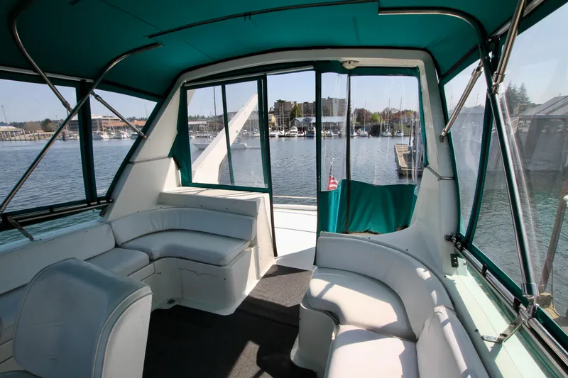  Yacht Photos Pics Interior of 1999 McKinna 47 Sedan yacht with white seating and marina view.
