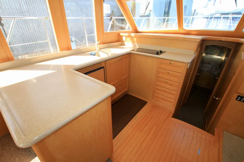  Yacht Photos Pics Interior of 1999 McKinna 47 Sedan yacht with modern kitchen and wooden cabinetry.