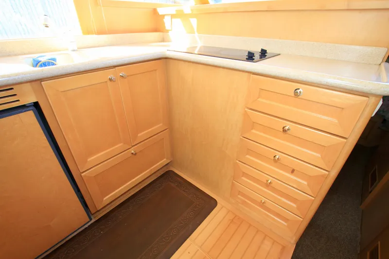  Yacht Photos Pics 1999 McKinna 47 Sedan yacht kitchen with wooden cabinets and countertop.
