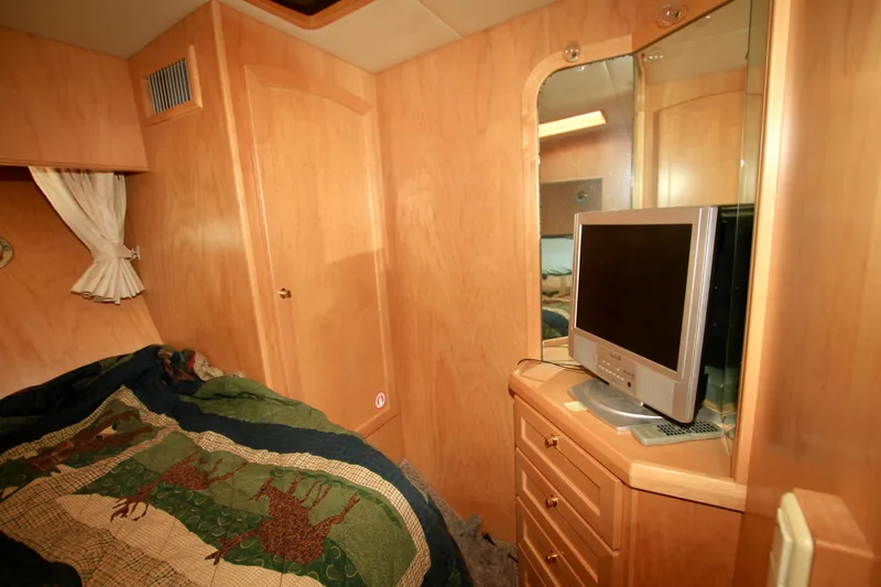  Yacht Photos Pics Cozy cabin interior of 1999 McKinna 47 Sedan with TV and wooden furnishings.