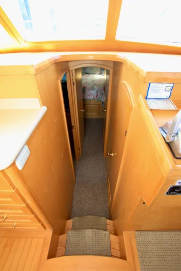  Yacht Photos Pics Interior view of 1999 McKinna 47 Sedan yacht, featuring wooden cabinetry and carpeted hallway.
