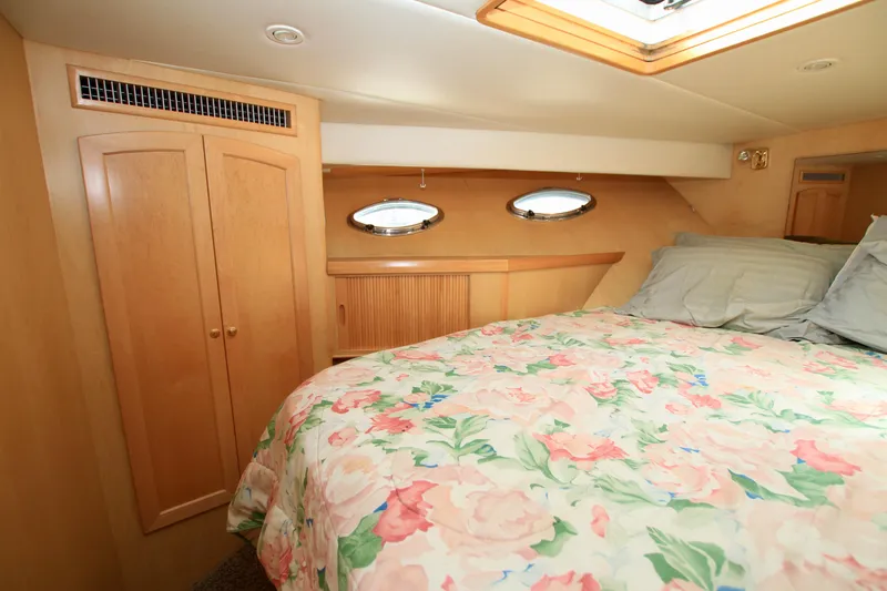  Yacht Photos Pics Cozy bedroom in 1999 McKinna 47 Sedan yacht with floral bedding and wooden cabinetry.