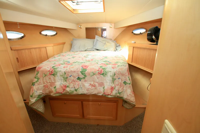 Yacht Photos Pics Cozy bedroom in 1999 McKinna 47 Sedan yacht with floral bedding and wood accents.