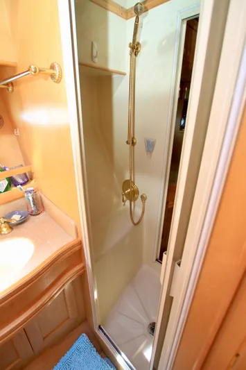  Yacht Photos Pics Shower area in 1999 McKinna 47 Sedan yacht, featuring gold fixtures and compact design.