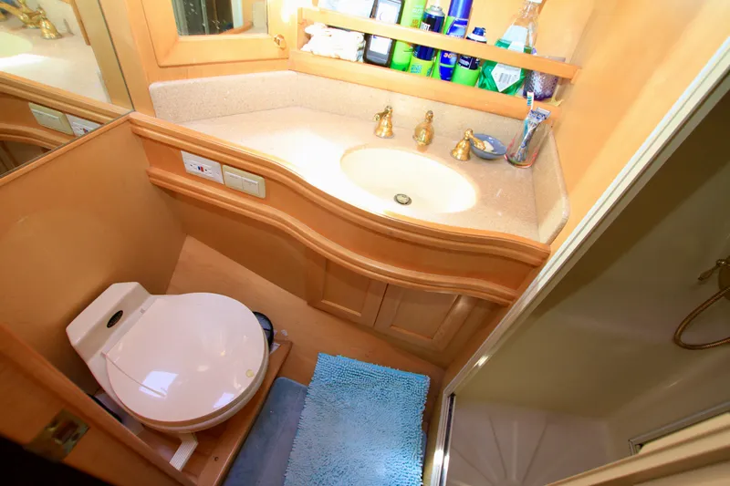  Yacht Photos Pics Bathroom interior of 1999 McKinna 47 Sedan yacht with sink, toilet, and shower.