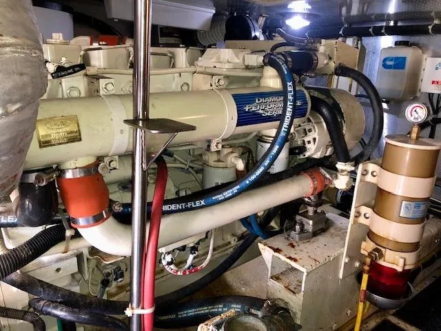  Yacht Photos Pics Engine room of a 1999 McKinna 47 Sedan yacht, showcasing complex machinery and hoses.