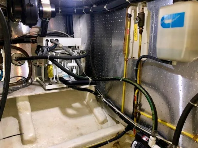  Yacht Photos Pics Engine room of a 1999 McKinna 47 Sedan with visible hoses and equipment.
