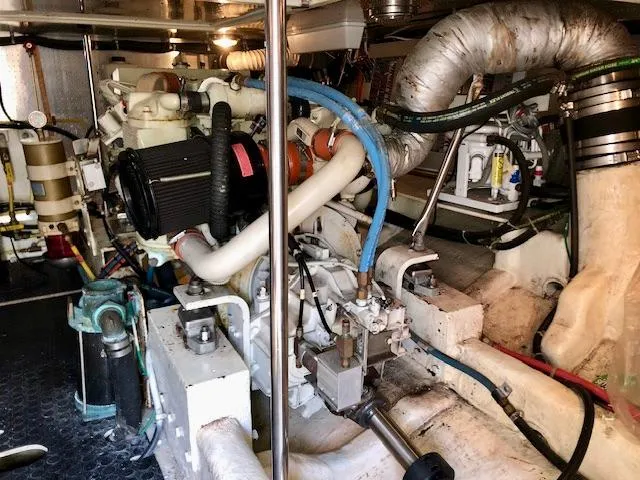  Yacht Photos Pics Engine room of a 1999 McKinna 47 Sedan yacht, showcasing complex machinery and piping.