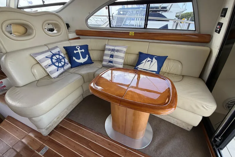  Yacht Photos Pics Luxurious 2007 Cranchi Atlantique 40 yacht interior with nautical-themed cushions and elegant wooden table.