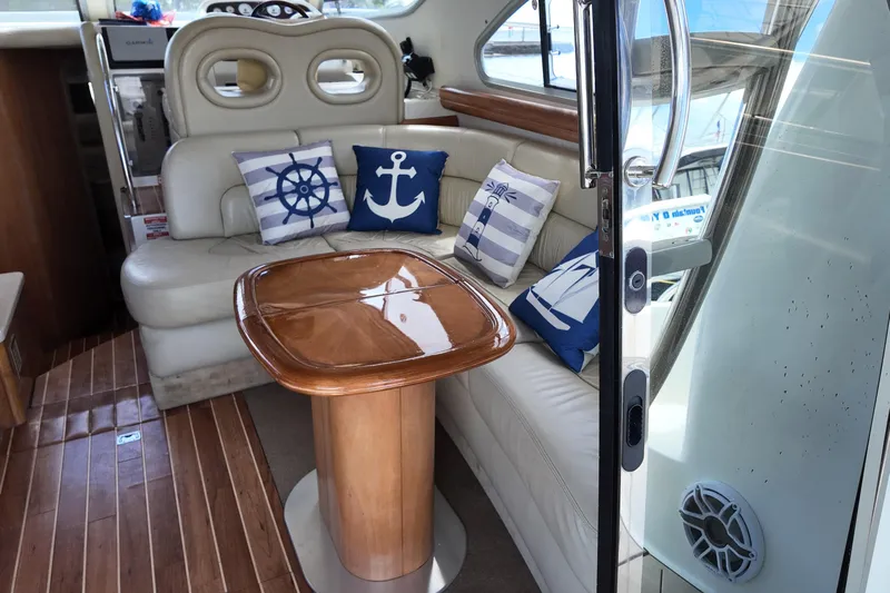  Yacht Photos Pics Interior of 2007 Cranchi Atlantique 40 yacht with nautical-themed cushions and wooden table.