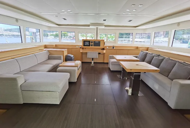 Er Yue Hua Hao Yacht Photos Pics Spacious interior of 2014 Lagoon 620 catamaran with modern seating and panoramic windows.