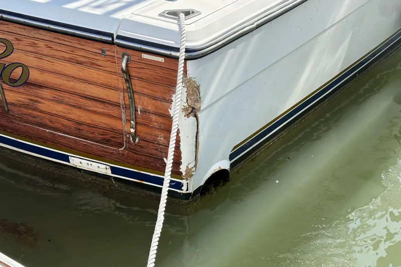 Free 2 Go Yacht Photos Pics 2006 Rampage 38 Express boat with visible hull damage near waterline.