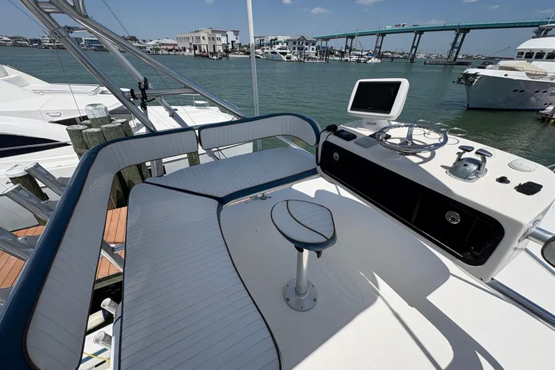 Free 2 Go Yacht Photos Pics 2006 Rampage 38 Express boat helm with seating, docked near a bridge and waterfront buildings.