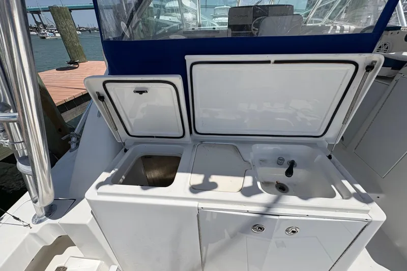 Free 2 Go Yacht Photos Pics 2006 Rampage 38 Express boat with open storage compartments and sink on deck.