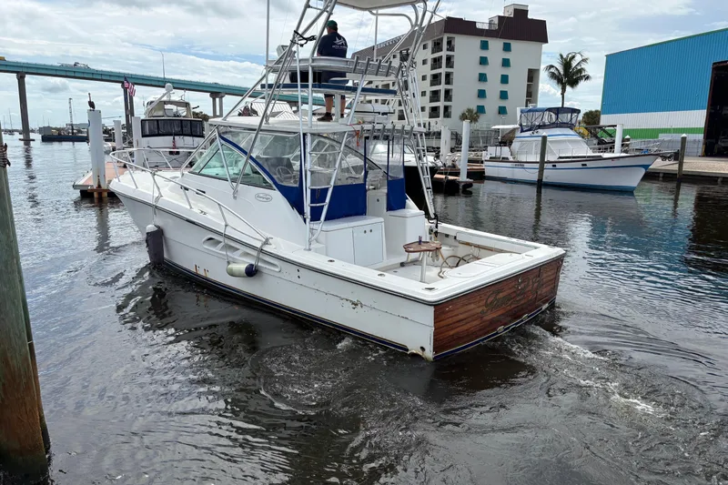 Free 2 Go Yacht Photos Pics 2006 Rampage 38 Express boat docked in a marina, with a bridge and buildings nearby.