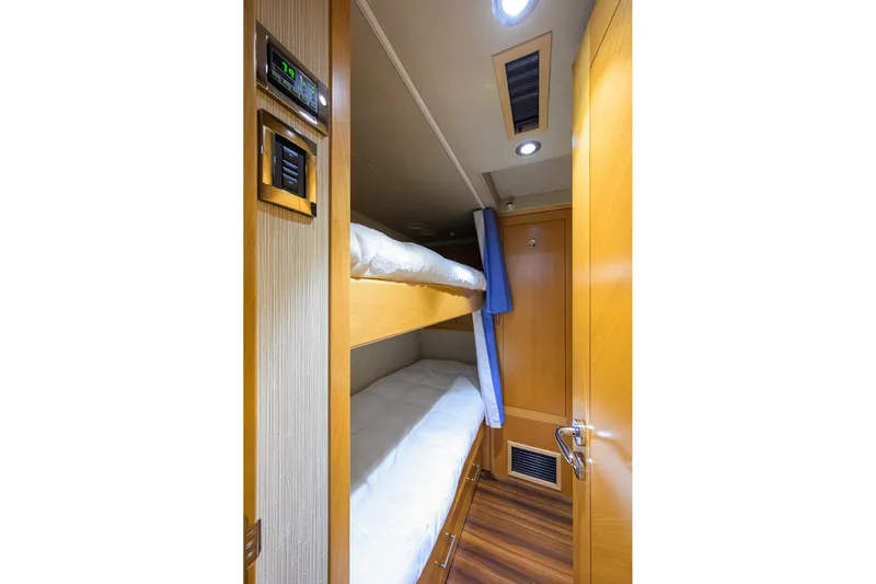 Remy Roo Yacht Photos Pics Cozy bunk bed cabin in 2014 Westport 112 yacht, featuring wood paneling and modern lighting.