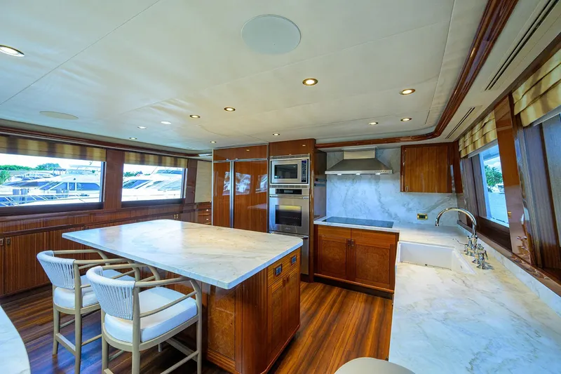 Remy Roo Yacht Photos Pics Luxurious kitchen interior on 2014 Westport 112 yacht with marble countertops and wooden cabinetry.