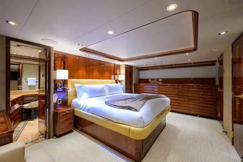 Remy Roo Yacht Photos Pics Luxurious bedroom interior on 2014 Westport 112 yacht, featuring elegant wood finishes and plush bedding.