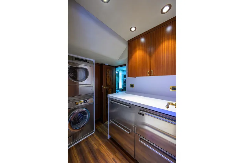 Remy Roo Yacht Photos Pics Laundry area in 2014 Westport 112 yacht with wood cabinets and stainless steel appliances.