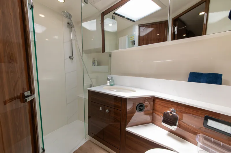 One More Yacht Photos Pics Luxurious bathroom in 2024 Maritimo M55 yacht with modern fixtures and elegant wood cabinetry.