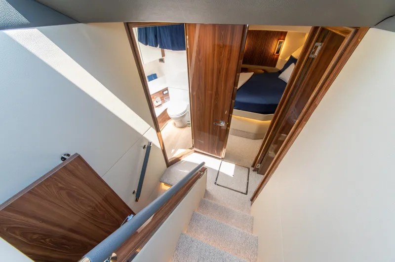 One More Yacht Photos Pics 2024 Maritimo M55 yacht interior with stairs, bedroom, and bathroom.