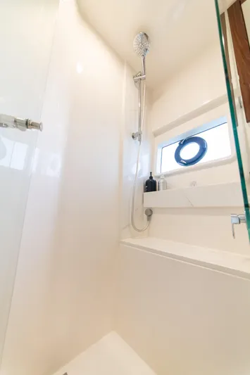 One More Yacht Photos Pics Luxurious shower area in 2024 Maritimo M55 yacht, featuring modern fixtures and a porthole window.