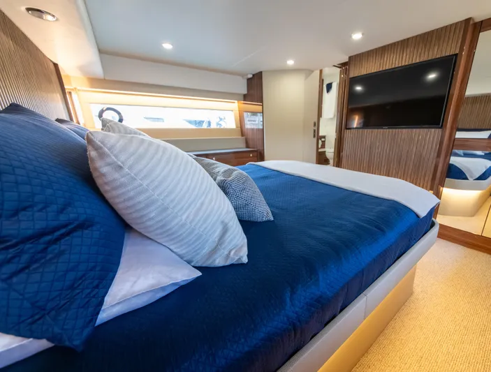 One More Yacht Photos Pics Luxurious bedroom interior of 2024 Maritimo M55 yacht with blue bedding and modern decor.