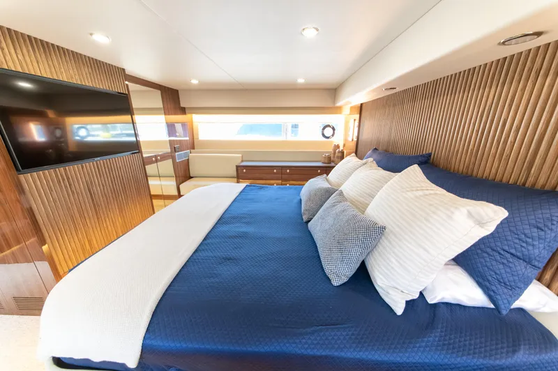 One More Yacht Photos Pics Luxurious bedroom interior of 2024 Maritimo M55 yacht with elegant wood paneling and plush bedding.