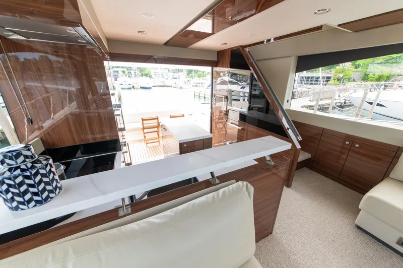 One More Yacht Photos Pics Luxurious interior of 2024 Maritimo M55 yacht with elegant wood finishes and marina view.