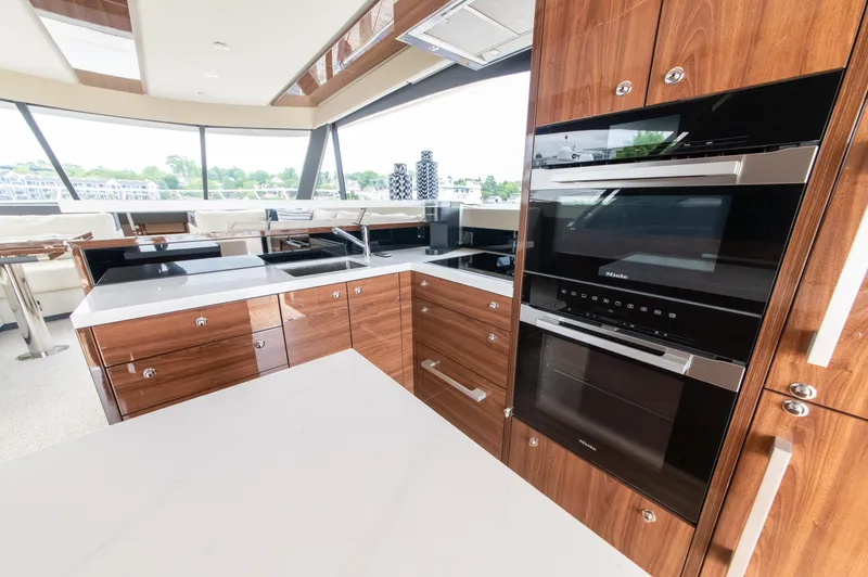 One More Yacht Photos Pics Luxurious kitchen interior of 2024 Maritimo M55 yacht with modern appliances and wood cabinetry.