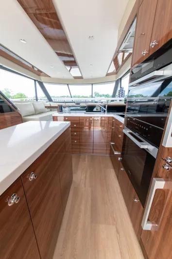 One More Yacht Photos Pics Luxurious kitchen interior of 2024 Maritimo M55 yacht with modern wood finishes and appliances.