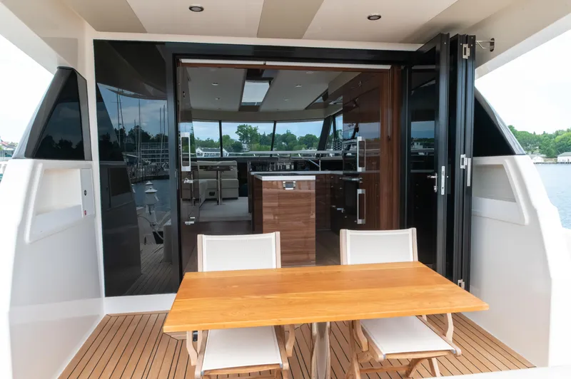 One More Yacht Photos Pics 2024 Maritimo M55 yacht with open deck, wooden table, and modern interior view.