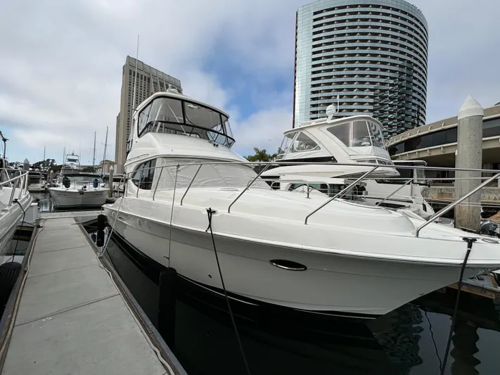  Yacht Photos Pics 2004 Silverton 38 Convertible yacht docked in marina, city skyline in background.