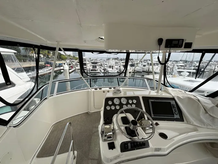  Yacht Photos Pics Interior view of 2004 Silverton 38 Convertible yacht helm with marina background.