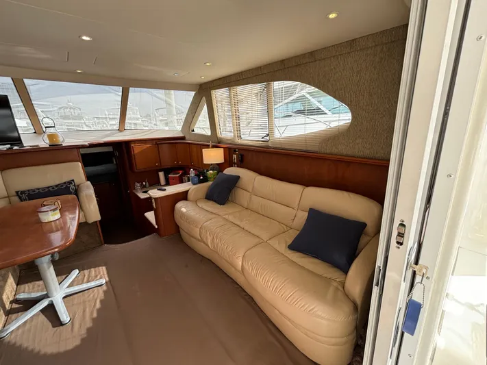  Yacht Photos Pics 2004 Silverton 38 Convertible yacht interior with beige leather sofa and wooden accents.