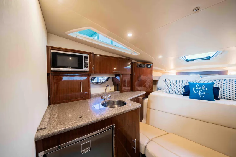 Dawg House Yacht Photos Pics Luxurious interior of 2015 Regal 35 Sport Coupe with kitchenette and cozy seating area.