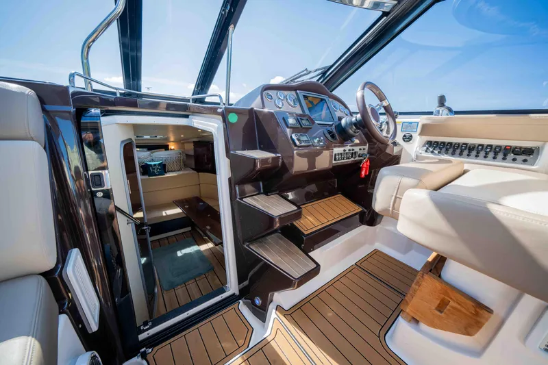 Dawg House Yacht Photos Pics Interior of 2015 Regal 35 Sport Coupe, featuring helm and cabin entrance.