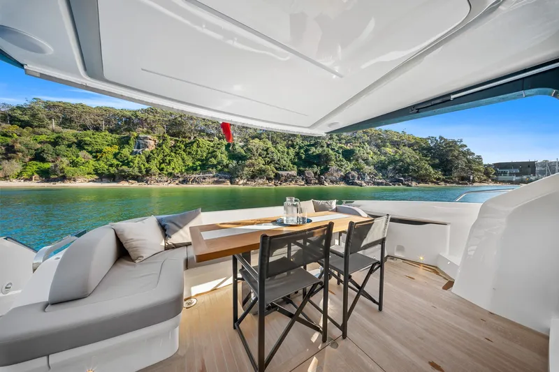 2023 Pearl 62 Luxury Yacht Yacht Photos Pics Luxurious Pearl 62 yacht deck with seating, table, and scenic waterfront view, 2023 model.