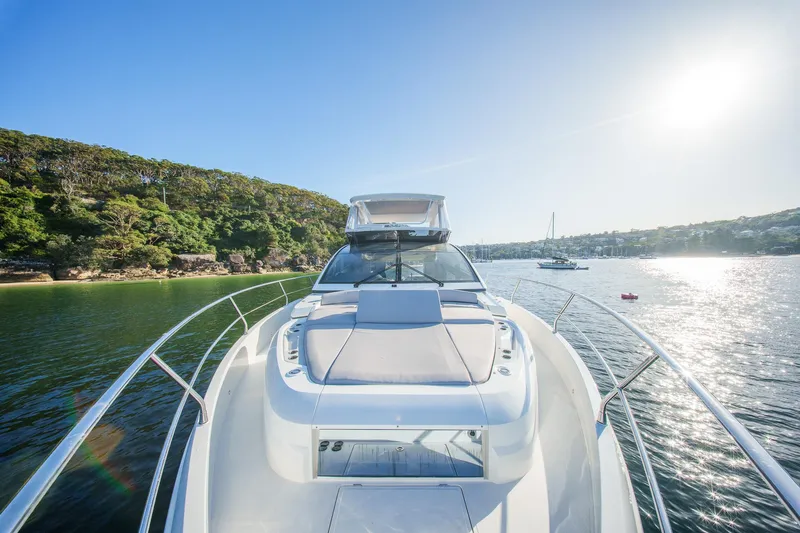 2023 Pearl 62 Luxury Yacht Yacht Photos Pics Luxurious 2023 Pearl 62 yacht cruising on a sunny day, surrounded by scenic waters and lush greenery.