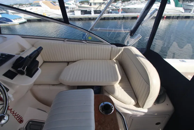 Karma Sea's Yacht Photos Pics 2001 Grady-White Express 330 boat interior with cream seating and helm, docked at marina.