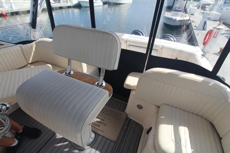 Karma Sea's Yacht Photos Pics Interior of 2001 Grady-White Express 330 boat with white seating and marina view.