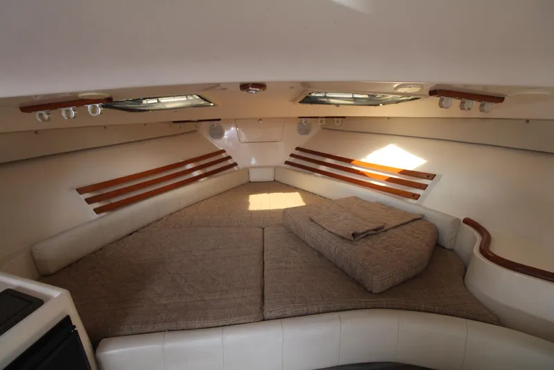 Karma Sea's Yacht Photos Pics 2001 Grady-White Express 330 cabin interior with cushioned seating and wooden accents.