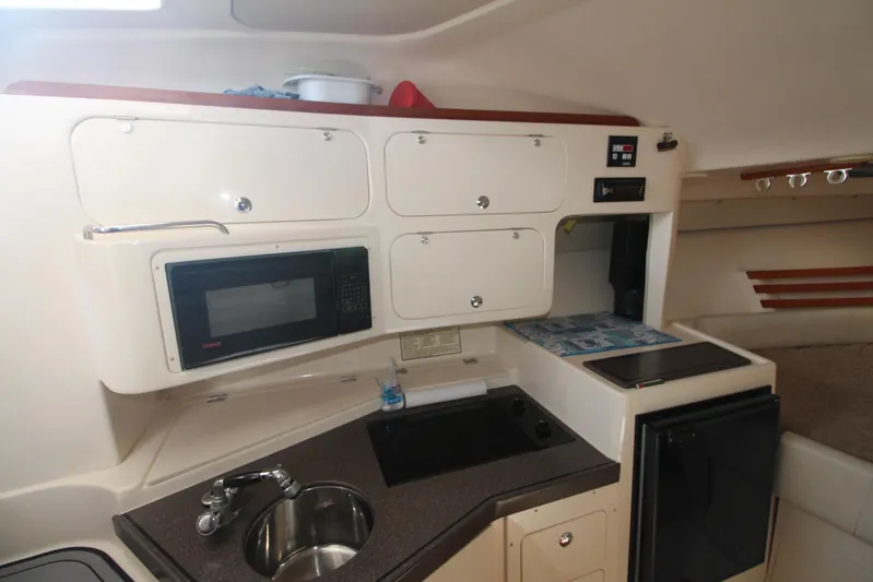 Karma Sea's Yacht Photos Pics 2001 Grady-White Express 330 boat kitchen with sink, microwave, and storage cabinets.
